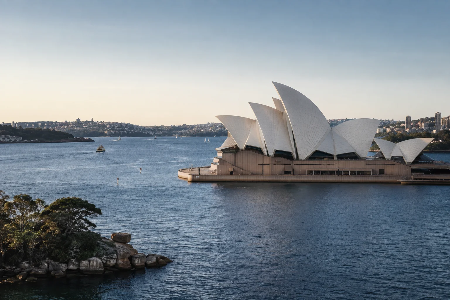 Sydney Opera House across a quiet blue harbour